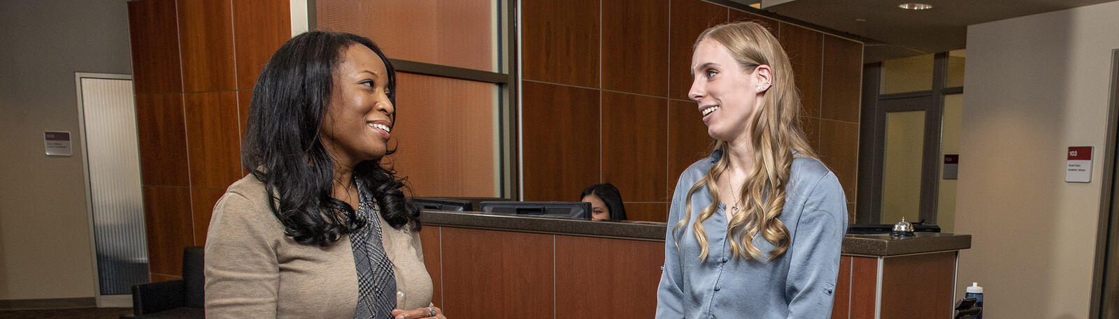 photo of a student talking to a staff member