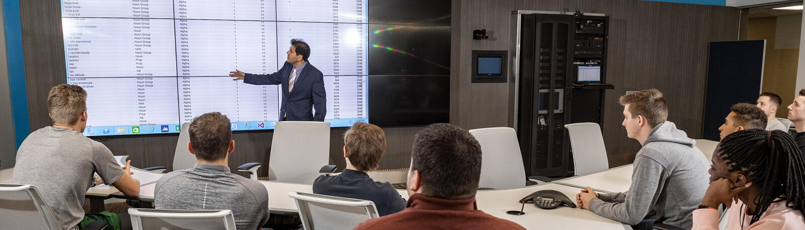 photo of a professor and students in a class in the data analytics and visualization environment